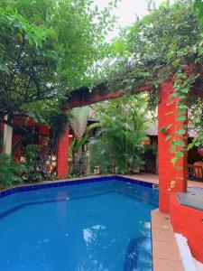 a swimming pool with an archway and trees at Hotel Centro Villarrica in Villarrica