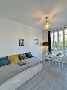 a bedroom with a bed and a table and a desk at Cosy Apartment near La Défense / Paris 4pers in La Garenne-Colombes