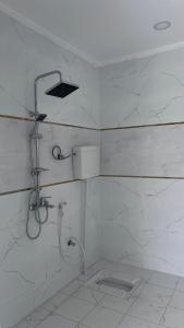 a white bathroom with a shower and a sink at استراحة النود in Al Nairyah