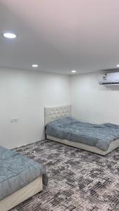 two twin beds in a room with a carpet at استراحة النود in Al Nairyah