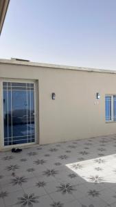 a white building with a large door and a tile floor at استراحة النود in Al Nairyah