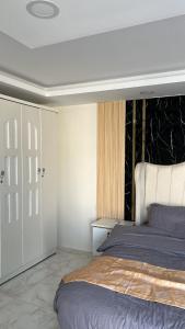 a bedroom with a bed with a black and white headboard at استراحة النود in Al Nairyah