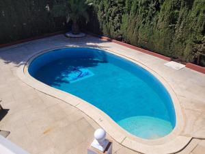 a large swimming pool with blue water in a backyard at VILLA ALEGRIA Big terrace, private pool & parking in Mijas