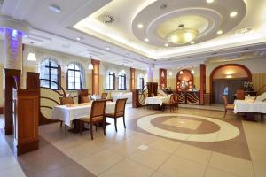 a restaurant with tables and chairs in a room at Hotel Nest in Gniezno