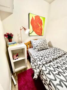 - une chambre avec un lit noir et blanc et un tapis rose dans l'établissement Tiny Private Room on the 1st Floor Shared Bathroom near Airport and Downtown Seattle, à Seattle