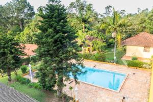 an aerial view of a villa with a tree and a swimming pool at Villa Bem Querer - Camomila in Mairiporã
