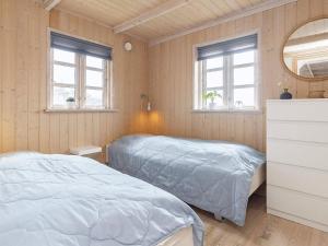 - une chambre avec 2 lits, un miroir et des fenêtres dans l'établissement Holiday home Løkken CXLVII, à Løkken