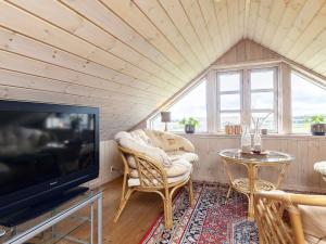 - un salon avec une télévision, une table et des chaises dans l'établissement Holiday home Løkken CXLVII, à Løkken