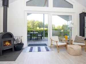 salon z kominkiem i patio w obiekcie 4 person holiday home in Haderslev w mieście Kelstrup Strand