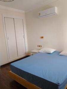 Schlafzimmer mit einem blauen Bett und weißen Schränken in der Unterkunft Chalet on the beach in Hurghada