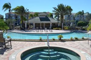 a large pool with chairs and a house in the background at Vista Cay Jewel Luxury Condo by Universal Orlando Rental in Orlando