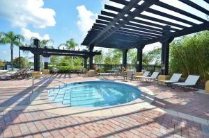 a swimming pool in a patio with chairs and a pergola at Vista Cay Jewel Luxury Condo by Universal Orlando Rental in Orlando