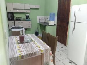 una pequeña cocina con mesa y nevera en Aluga-se uma casa em Mucugê Bahia en Mucugê