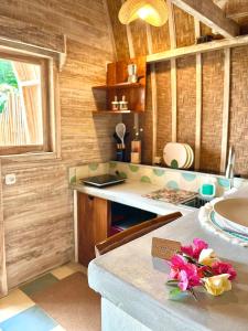 uma cozinha com paredes de madeira e um balcão com flores em Kalamanthana Bali - Nature with Modern Comfort em Selat