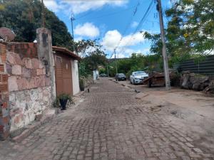 a cobblestone street with cars parked on the side at Aluga-se uma casa em Mucugê Bahia in Mucugê +14 photos