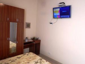 a bedroom with a bed and a television on the wall at Departamento confortable en Guaymallén in Guaymallen