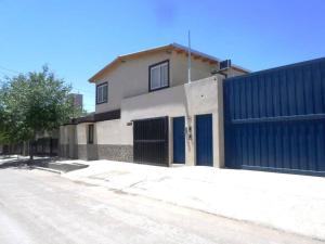 a building with a blue fence next to a street at Departamento confortable en Guaymallén in Guaymallen