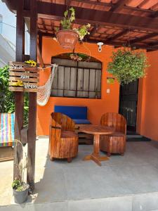 a patio with a table and chairs and an orange wall at Espaço Nill in Belo Horizonte