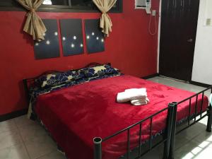 1 dormitorio rojo con 1 cama con pared roja en Aladino Hostel, en Dasmariñas