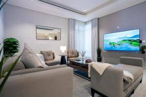 a living room with a couch and a flat screen tv at Golden Yasmin in Riyadh