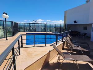 uma varanda com cadeiras e uma piscina em Flat particular no Lets Idea Brasília em Brasília