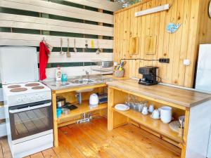 La cocina está equipada con fogones, fregadero y encimera. en kаравани Дрийм къмпинг Гардения en Kiten