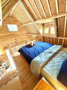 Cama en habitación con techo de madera en Kalamanthana Bali - Nature with Modern Comfort, en Selat