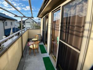 a small balcony with a chair and a window at 4 Bedrooms, 3 Toilets, 2 bathtubs, 2 car parking , 140 Square meter big Entire house close to Makuhari messe , Disneyland, Airports and Tokyo for 18 guests in Narashino