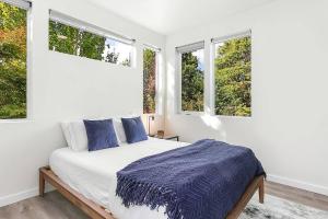 - une chambre blanche avec un lit et des fenêtres dans l'établissement Syrax's Dragonstone Den, à Seattle