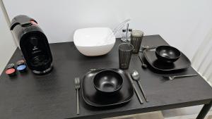 a table with black plates and utensils and a blender at Apartment Küche Arbeitsplatz Netflix WLan Barrierefrei in Augsburg