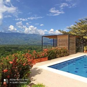 een zwembad naast een gebouw met uitzicht bij Casa de campo con piscina, en un clima ideal y un paisaje excepcional in Santa Fe de Antioquia