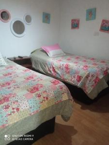 two beds sitting next to each other in a bedroom at Hostal¤ Familiar¤ in Chillán
