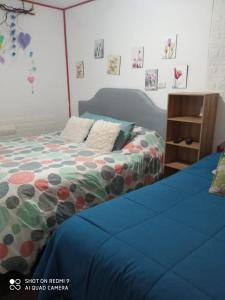 a bedroom with a bed with a blue comforter at Hostal¤ Familiar¤ in Chillán