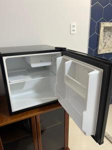 an empty refrigerator with its door open on a table at Residencial Berakah in Rio Verde