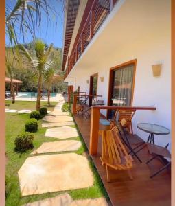 un patio con mesas, sillas y una mesa. en Paraíso Capitólio Suítes Pousada en Capitólio