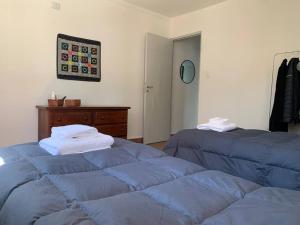 Duas camas azuis num quarto com uma cómoda em La casita de Isabella em Córdoba