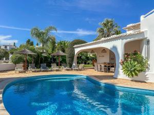 a swimming pool in front of a house at Luxury Villa Heated Pool, walk to São Rafael Beach, Albufeira in Albufeira