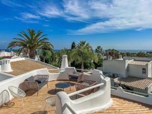 un patio con sillas y mesas en la azotea en Luxury Villa Heated Pool, walk to São Rafael Beach, Albufeira, en Albufeira