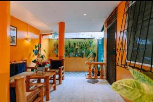 a living room with orange walls and a table and chairs at Malibu Homes in Casisang
