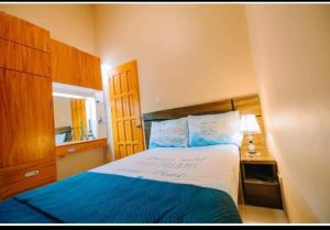 1 dormitorio con 1 cama con sábanas azules y blancas en Malibu Homes, en Casisang