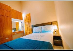 a bedroom with a bed with blue and white sheets at Malibu Homes in Casisang