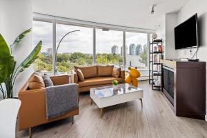 uma sala de estar com um sofá e uma televisão em GardenView Modern Condo with Parking, Gym, Pool, AC em Vancouver