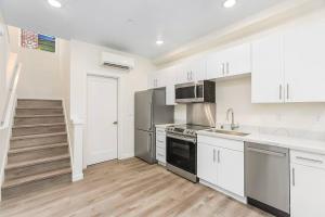 a kitchen with white cabinets and stainless steel appliances at Vhagar's Valyria's Vista in Seattle