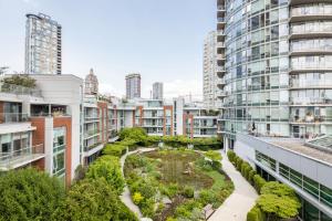 einen Apartment-Garten inmitten von Gebäuden in der Unterkunft GardenView Modern Condo with Parking, Gym, Pool, AC in Vancouver