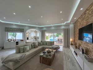 a large living room with a couch and a tv at Luxury Villa Heated Pool, walk to São Rafael Beach, Albufeira in Albufeira