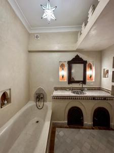 a bathroom with a bath tub and a fireplace at Riad Sakura Marrakech in Marrakesh
