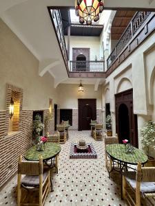 um átrio com duas mesas e cadeiras num edifício em Riad Sakura Marrakech em Marraquexe