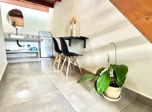 uma cozinha com uma mesa e um vaso de plantas em Barlavento Villas em Ilhabela