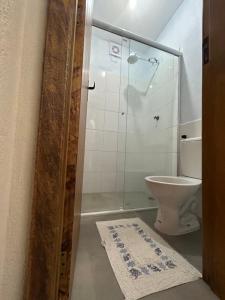 La salle de bains est pourvue de toilettes et d'une douche en verre. dans l'établissement Barlavento Villas, à Ilhabela