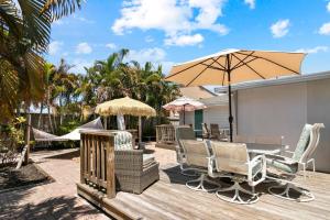 un patio con mesa, sillas y sombrilla en Parrot Bay Retreat en Sarasota